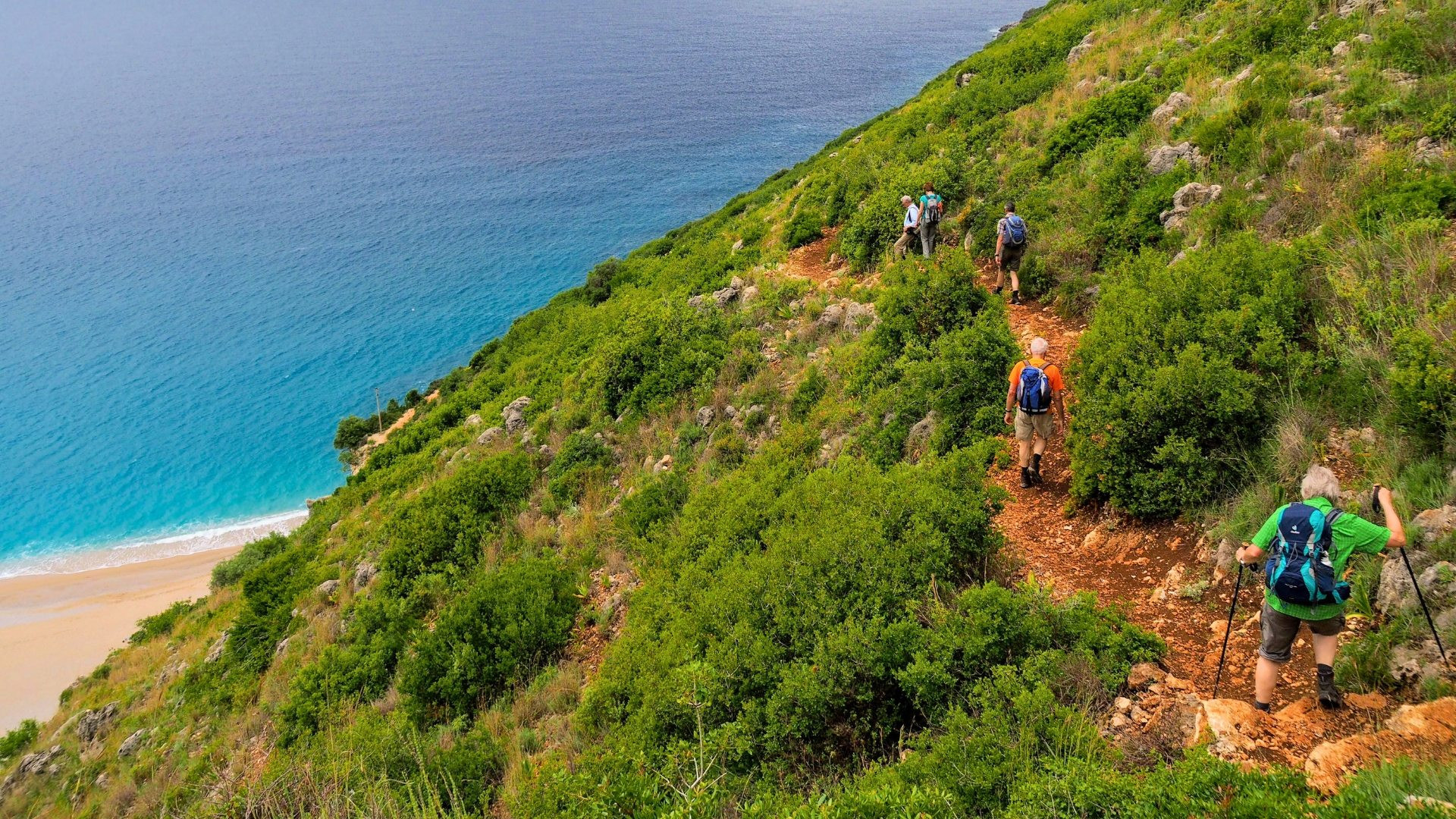 Randonneurs sur un sentier cotier surplombant une plage et la mer Ionienne - Riviera albanaise - Albanie
