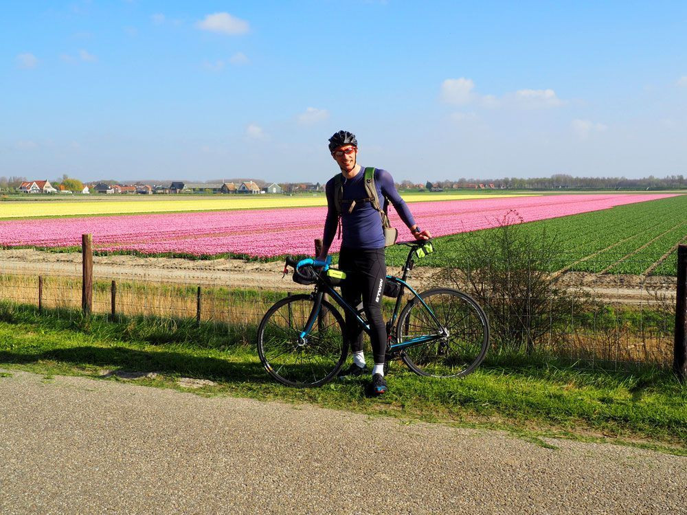 © David Praire À vélo devant un champ de tulipes à Oude-Tonge aux Pays-Bas © David Praire