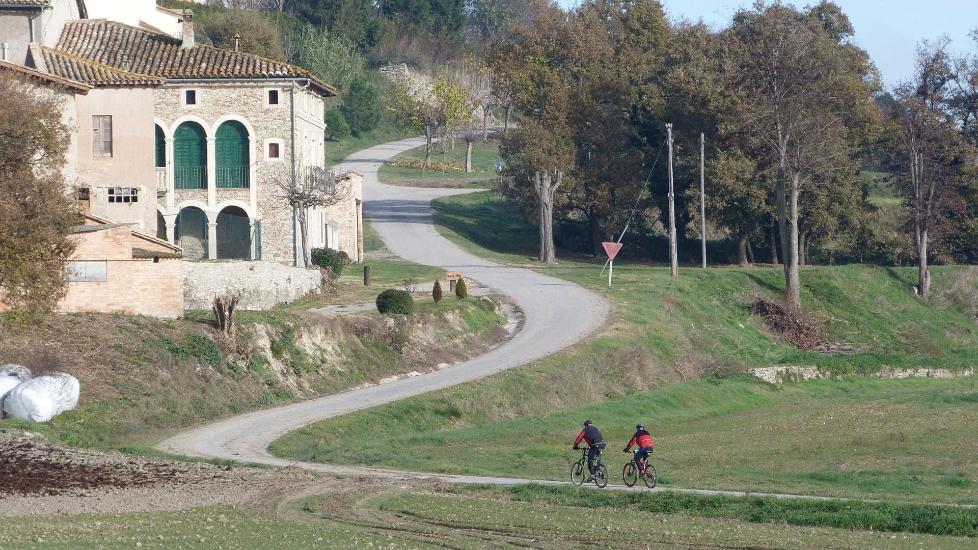 Cyclistes sur une route de campagne près d'un mas - entre Vic et Barcelone - Catalogne - Espagne