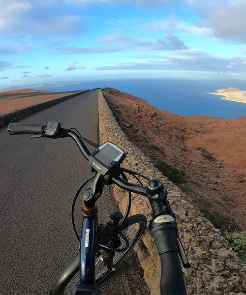 © David Praire Cycliste sur les routes volcaniques de Lanzarote surplombant la mer - Canaries - Espagne