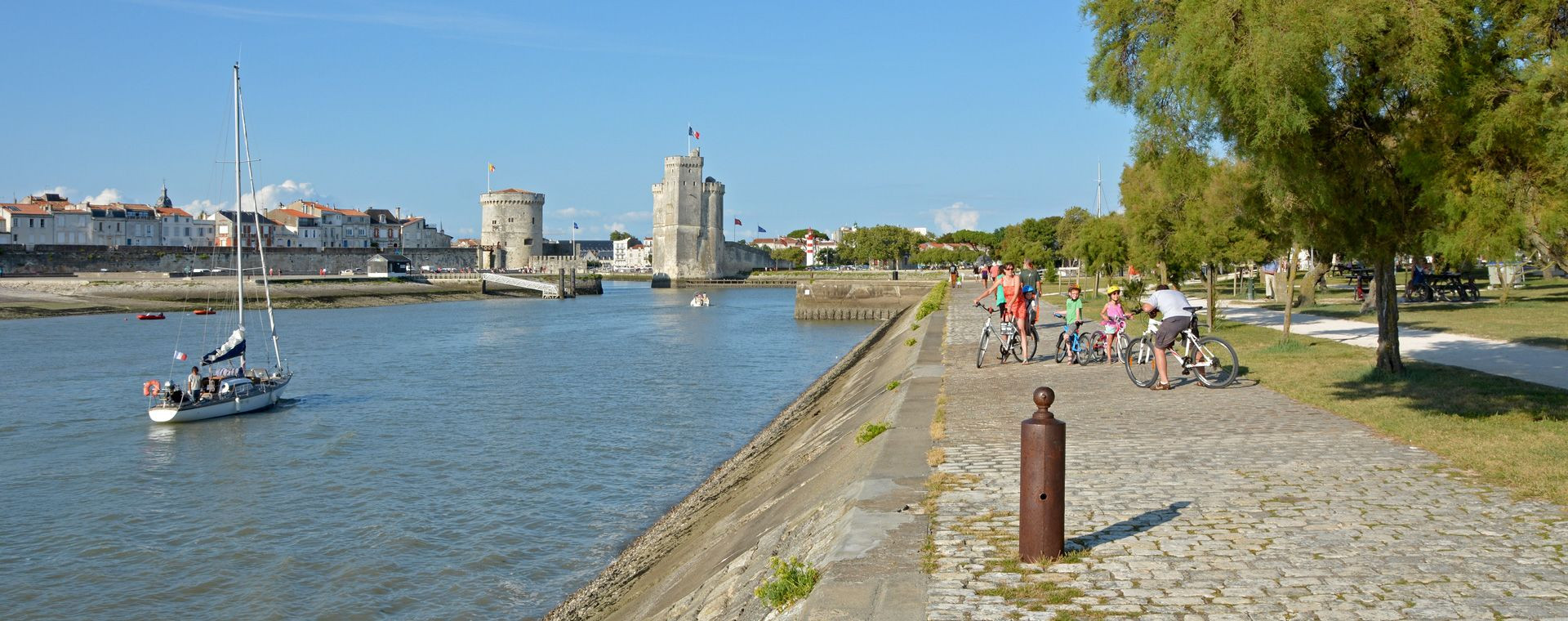 Cyclistes sur les quais face aux tours du Vieux-Port - La Rochelle - France