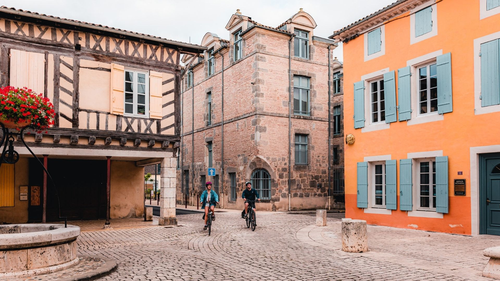 Cyclistes sur la place à colombages de Damazan - Lot-et-Garonne - France
