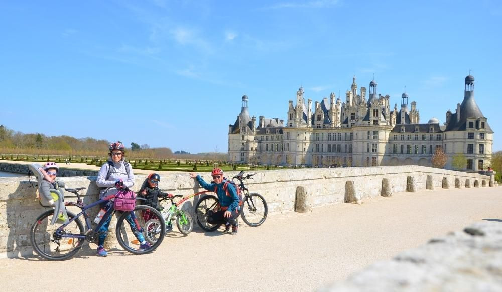 Famille à vélo devant le château de Chambord - Val de Loire - France