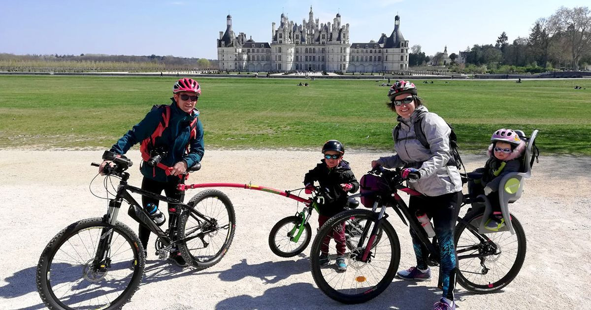 Famille à vélo devant le château de Chambord - Val de Loire - France