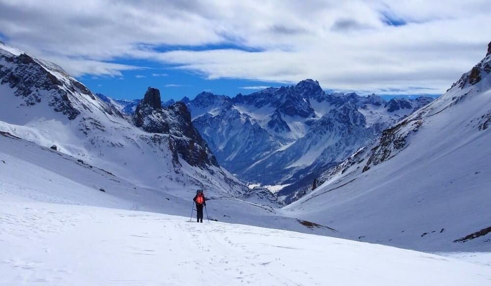 Randonneur à raquettes dans un vallon enneigé - Alpes - France