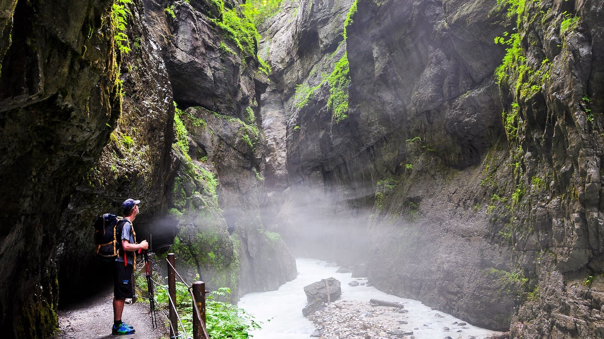© Johannes Braun Randonneur le long de la rivière dans la gorge brumeuse - Gorges de la Partnach - Bavière, Allemagne