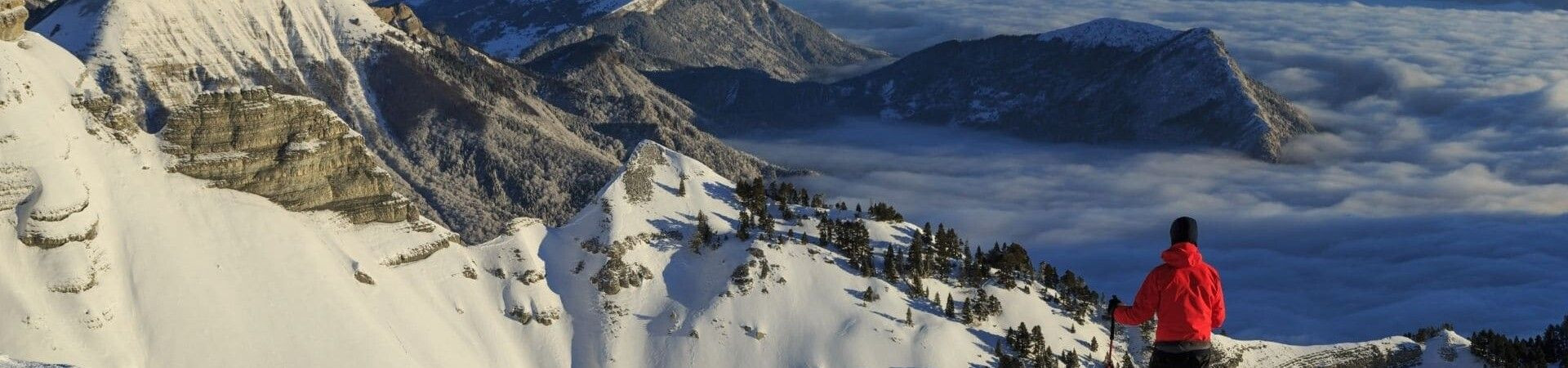 Randonneur contemplant les sommets enneigés au-dessus d'une mer de nuages - Vercors - France