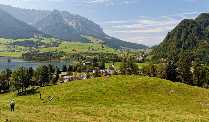 Randonneur dans une vallée alpine avec lac et village - Kaisergebirge - Tyrol - Autriche