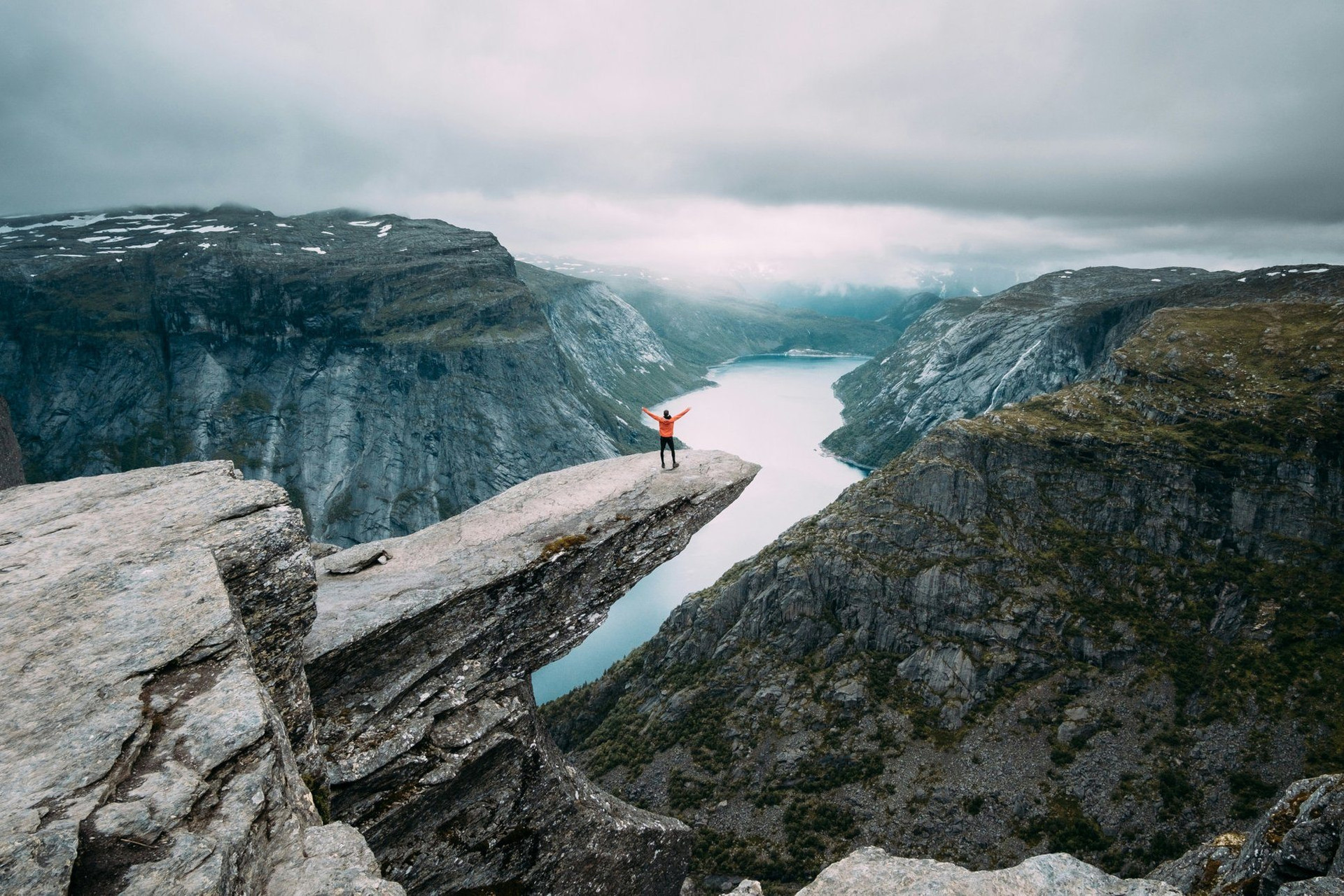 Randonneur sur Trolltunga surplombant un fjord - Norvège
