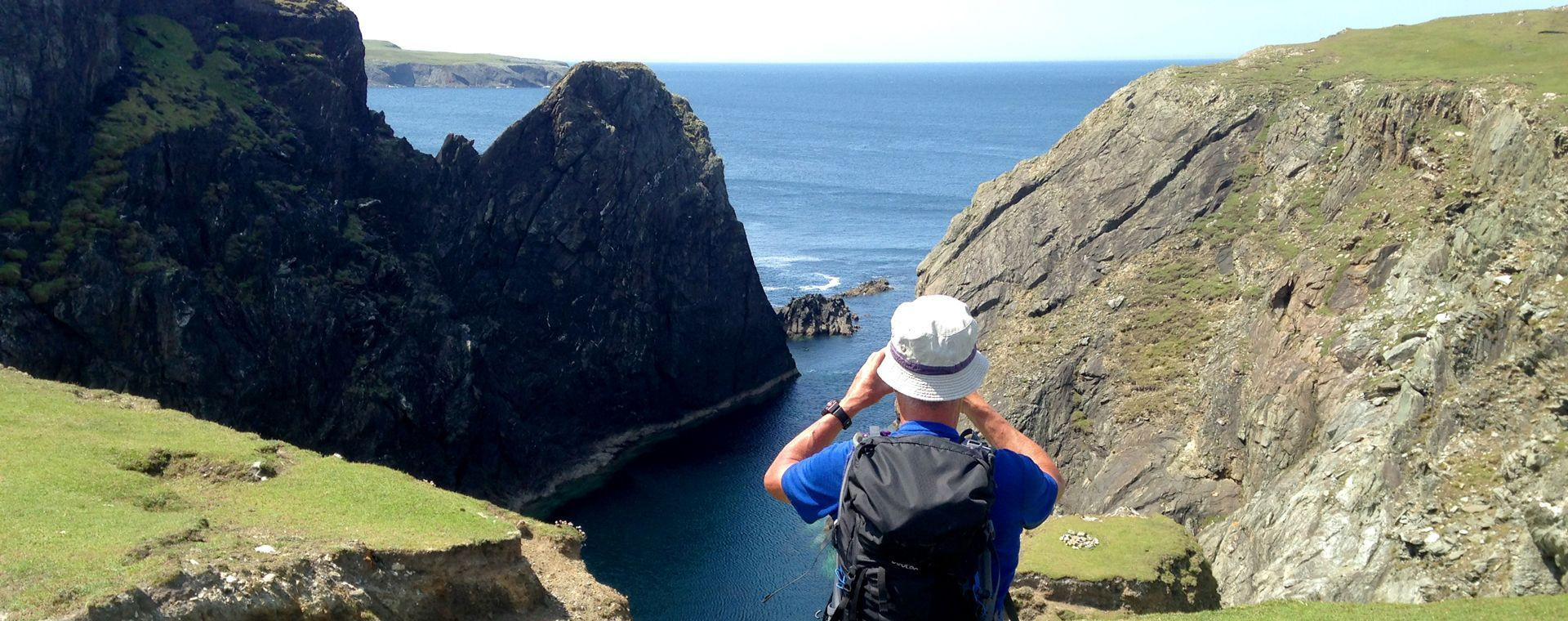Randonneur face aux falaises maritimes - Irlande