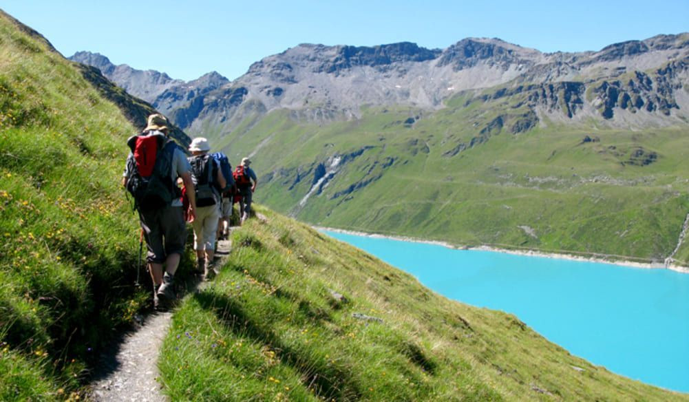 Randonneurs au-dessus d'un lac turquoise - Alpes suisses - Suisse