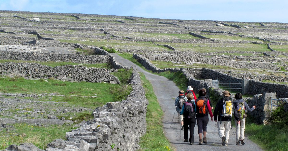 Randonneurs entre murets de pierre - Îles d'Aran - Irlande