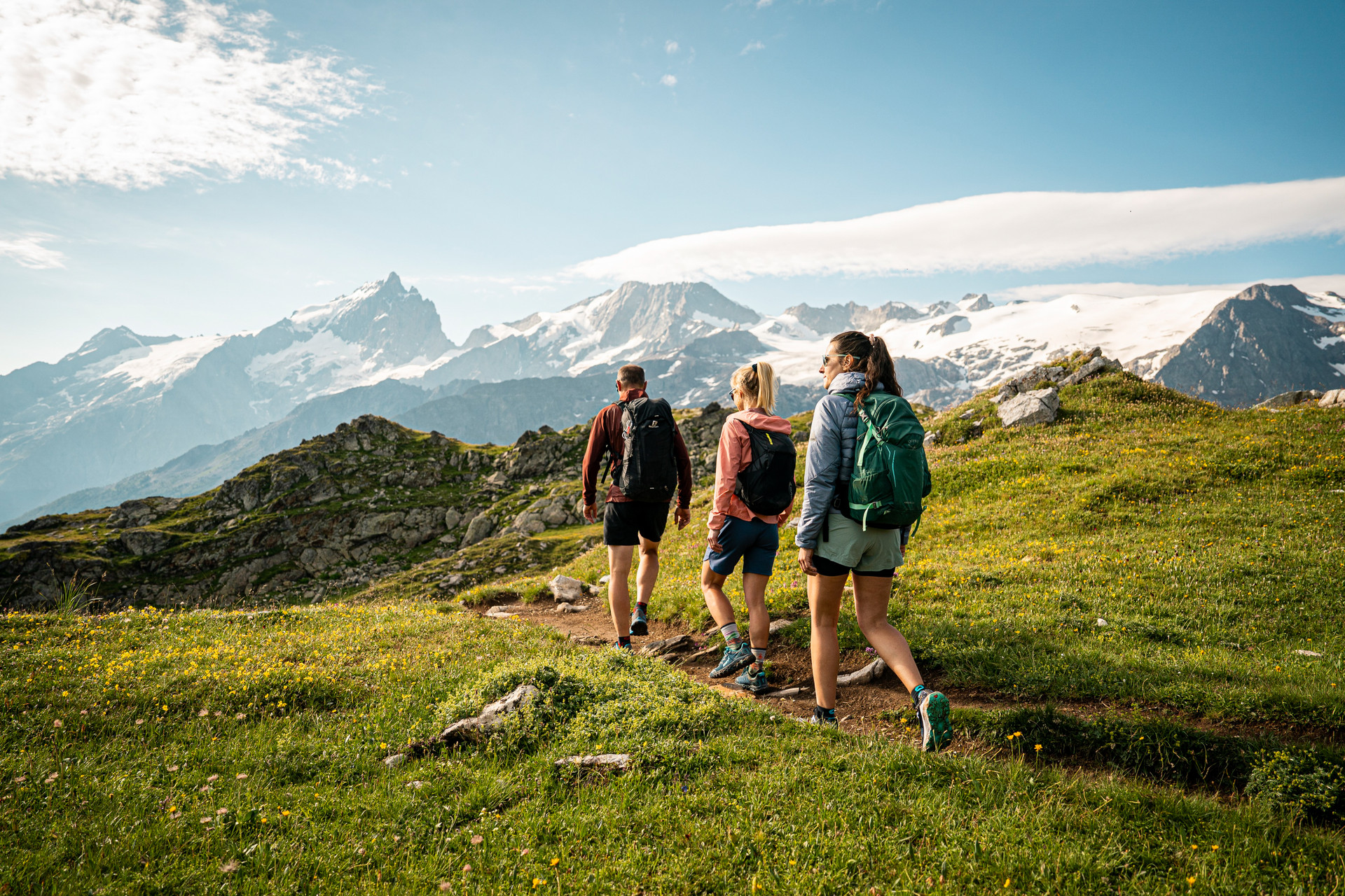 Benjamin Becker Trois randonneurs sur un sentier d'alpage face aux glaciers des Écrins
