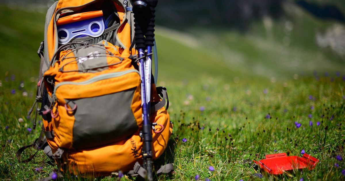 Sac à dos de randonnée et bâtons posés dans un alpage - Alpes