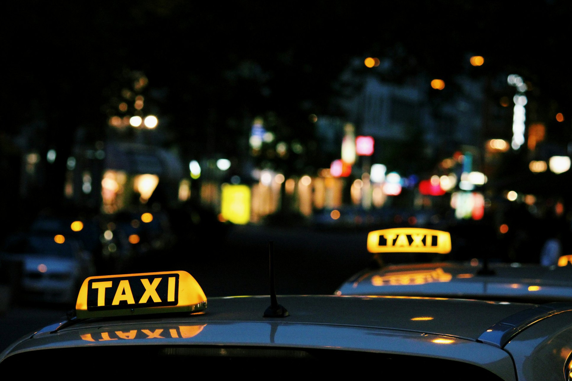 Enseignes lumineuses de taxis dans une rue la nuit