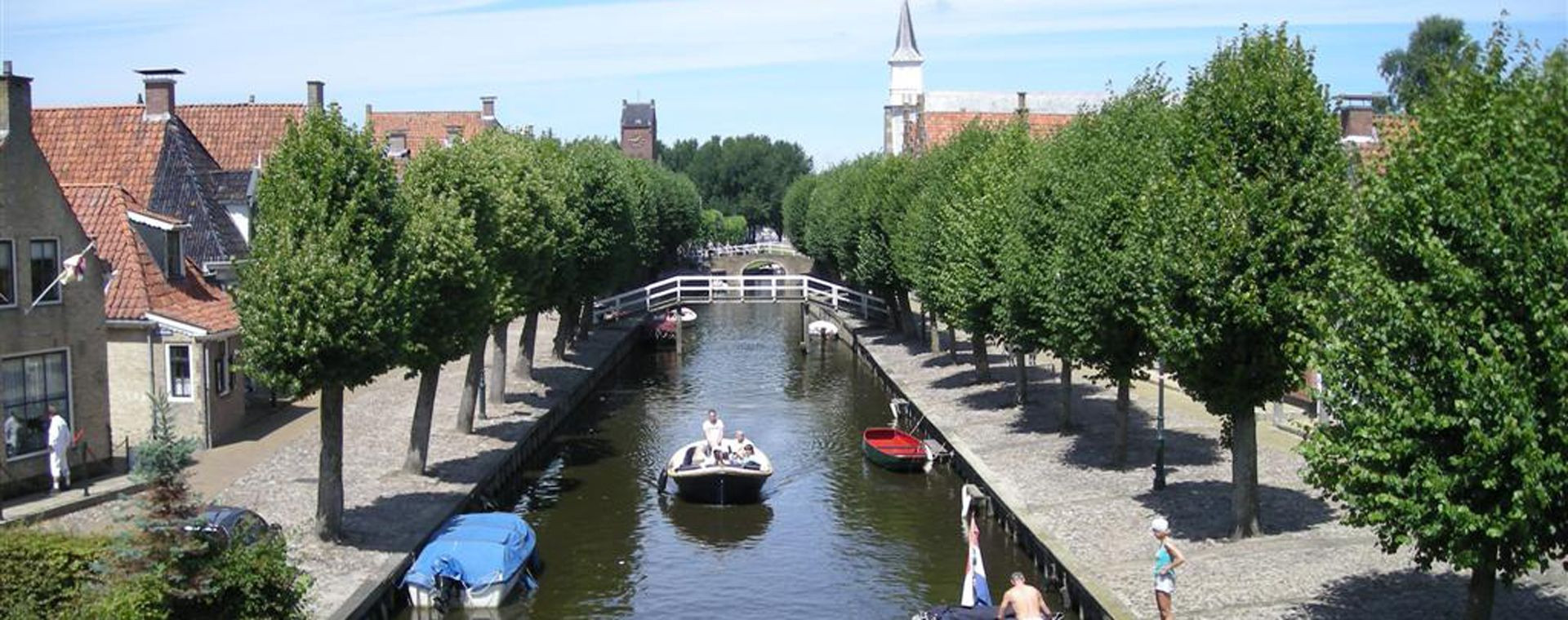 Canal bordé d'arbres avec barques - Sloten - Frise, Pays-Bas