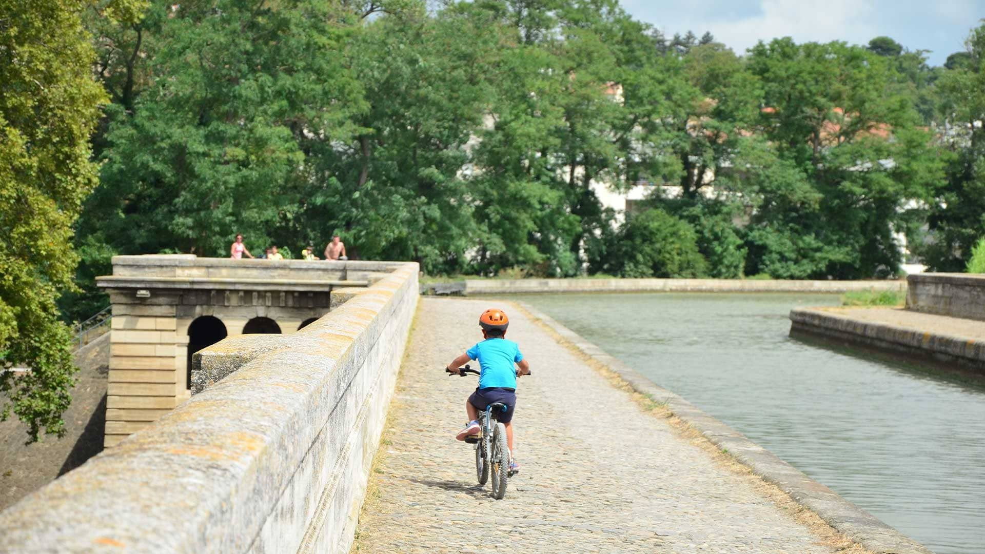 © Quentin Vanaker Enfant à vélo sur le pont-canal de l'Orb - Béziers - Canal du Midi - France