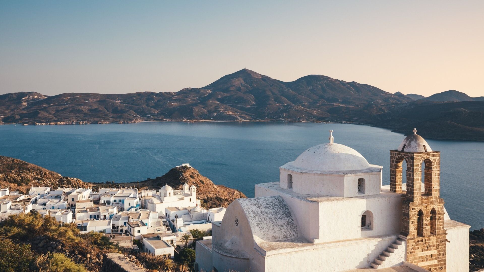 Une église et les maisons blanches de Plaka au-dessus de la baie de Milos