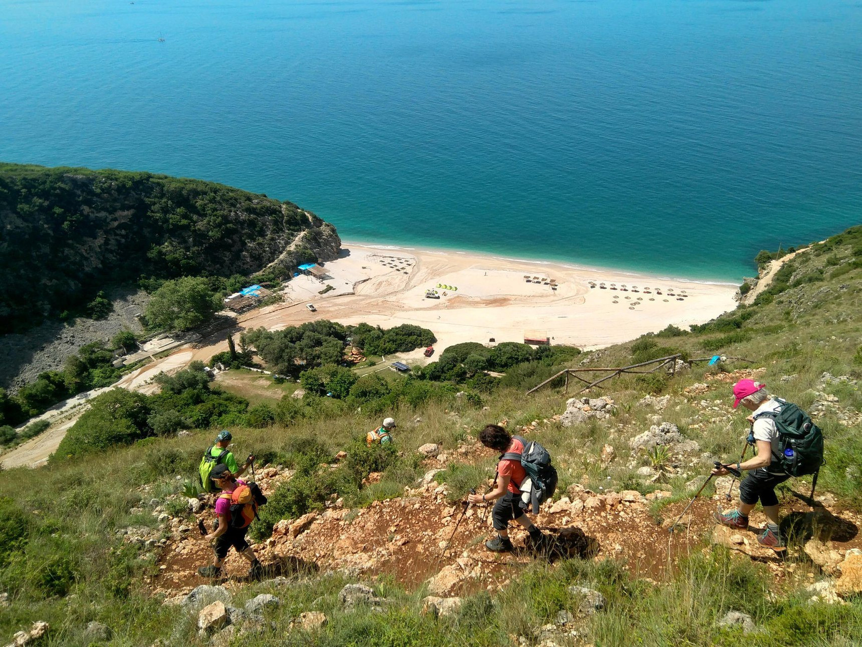 Photo de 3 randonneurs sur un sentier surplombant la mer