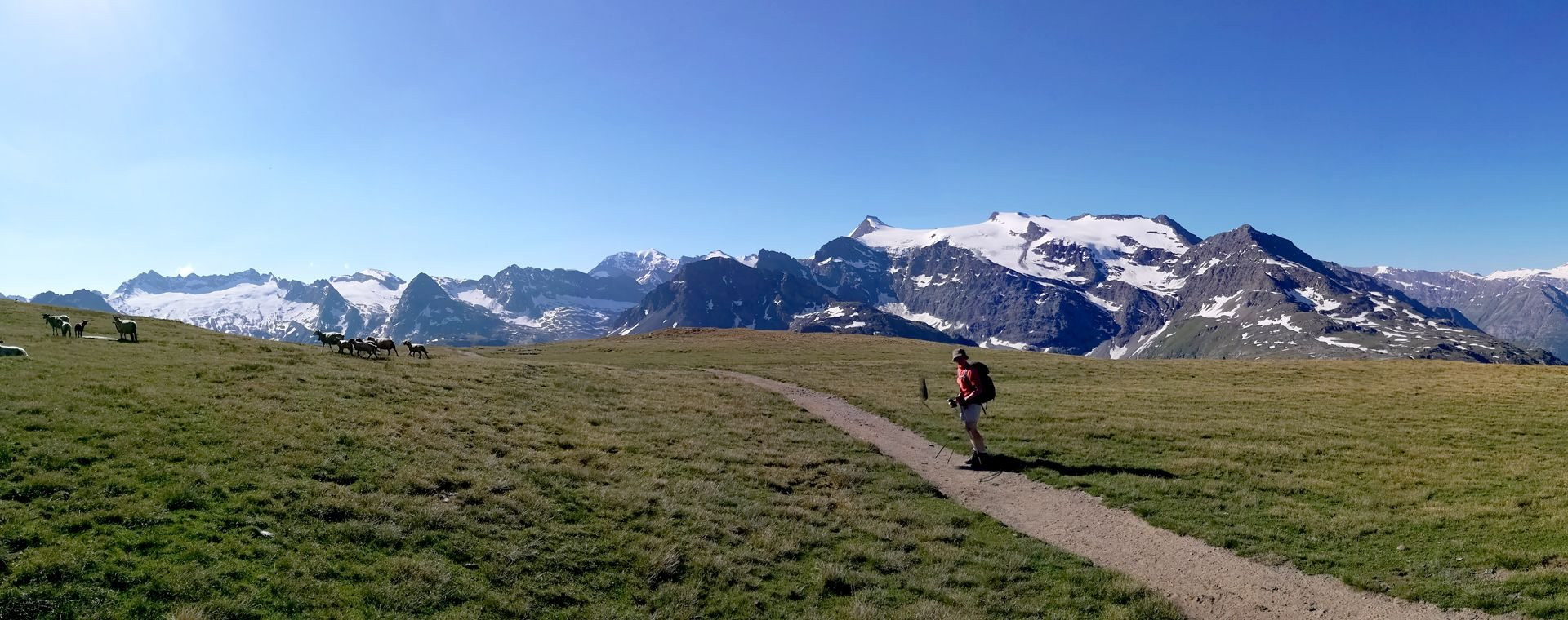 Randonneur sur sentier d'altitude face aux glaciers - Massif de la Vanoise - Alpes françaises