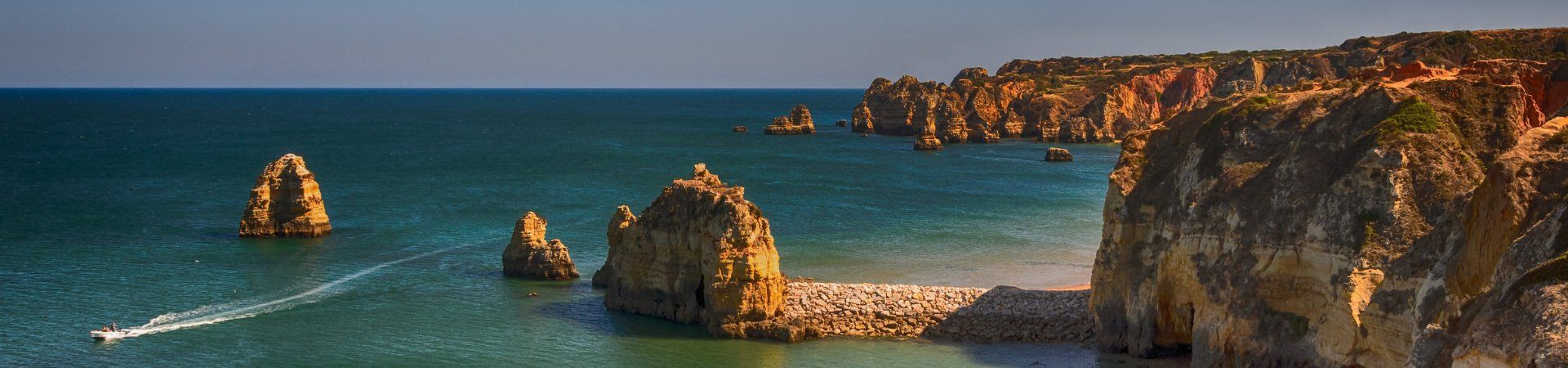 Falaises dorées et eaux turquoise avec bateau - Algarve - Portugal