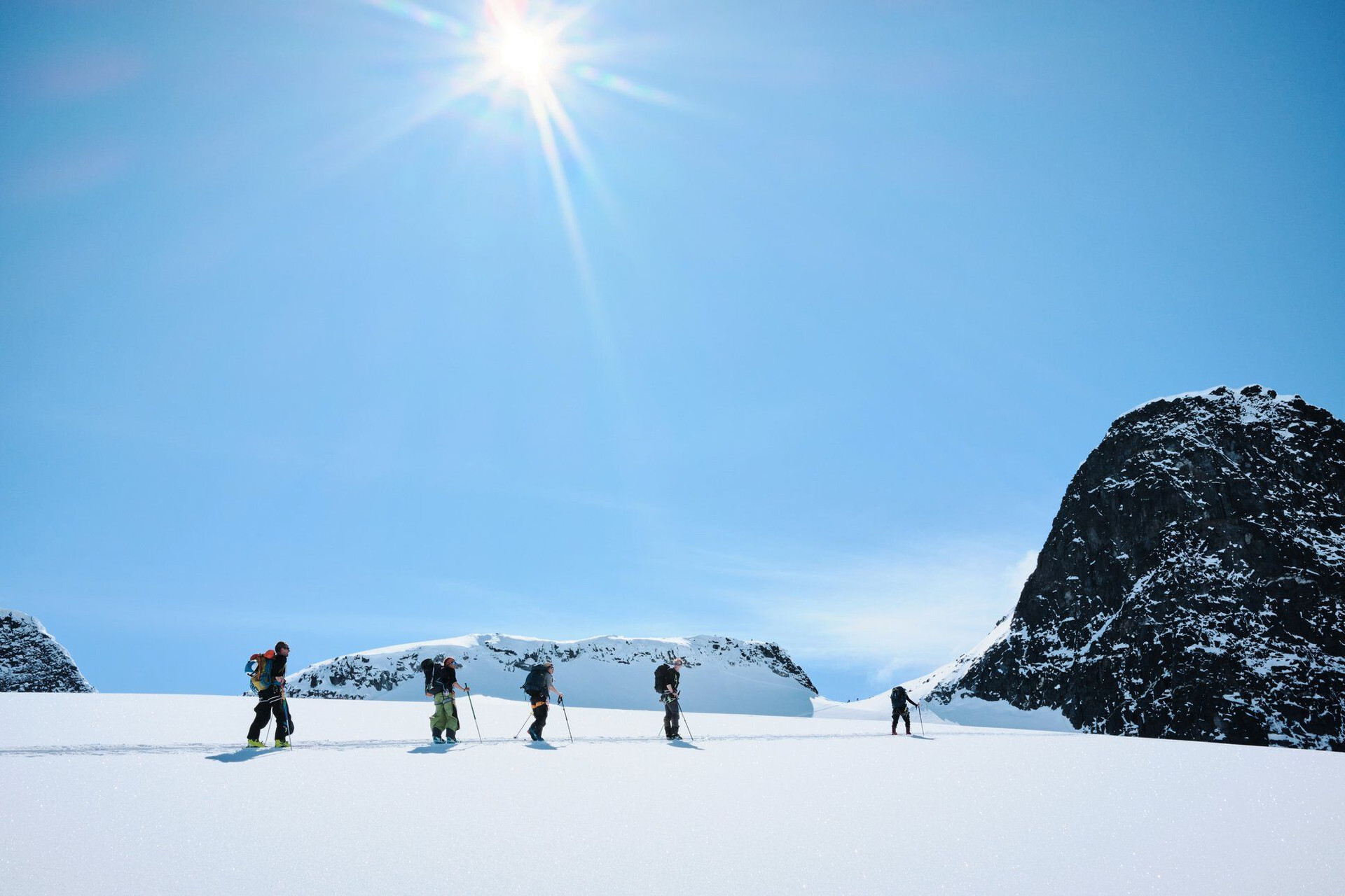 © Daniel Jacobsen Groupe de skieurs de randonnée à la montée sur un champ de neige - Scandinavie