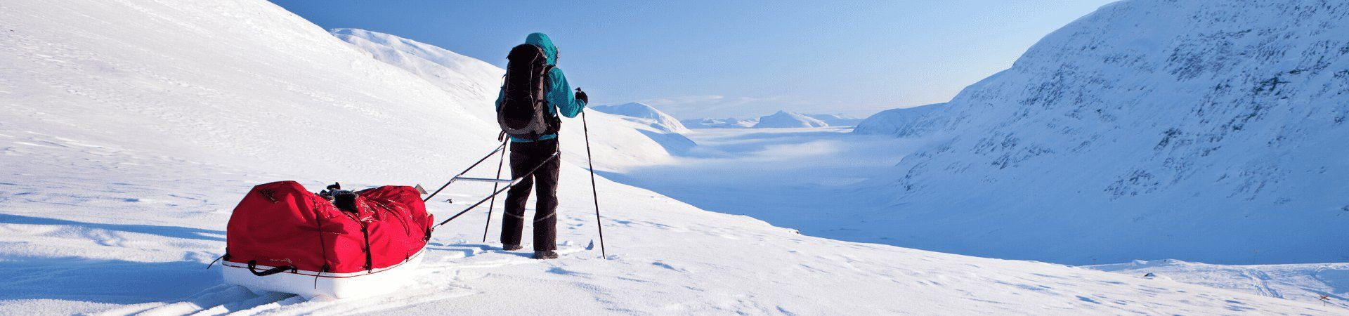 Skieuse tractant une pulka dans un paysage enneigé - Laponie - Suède