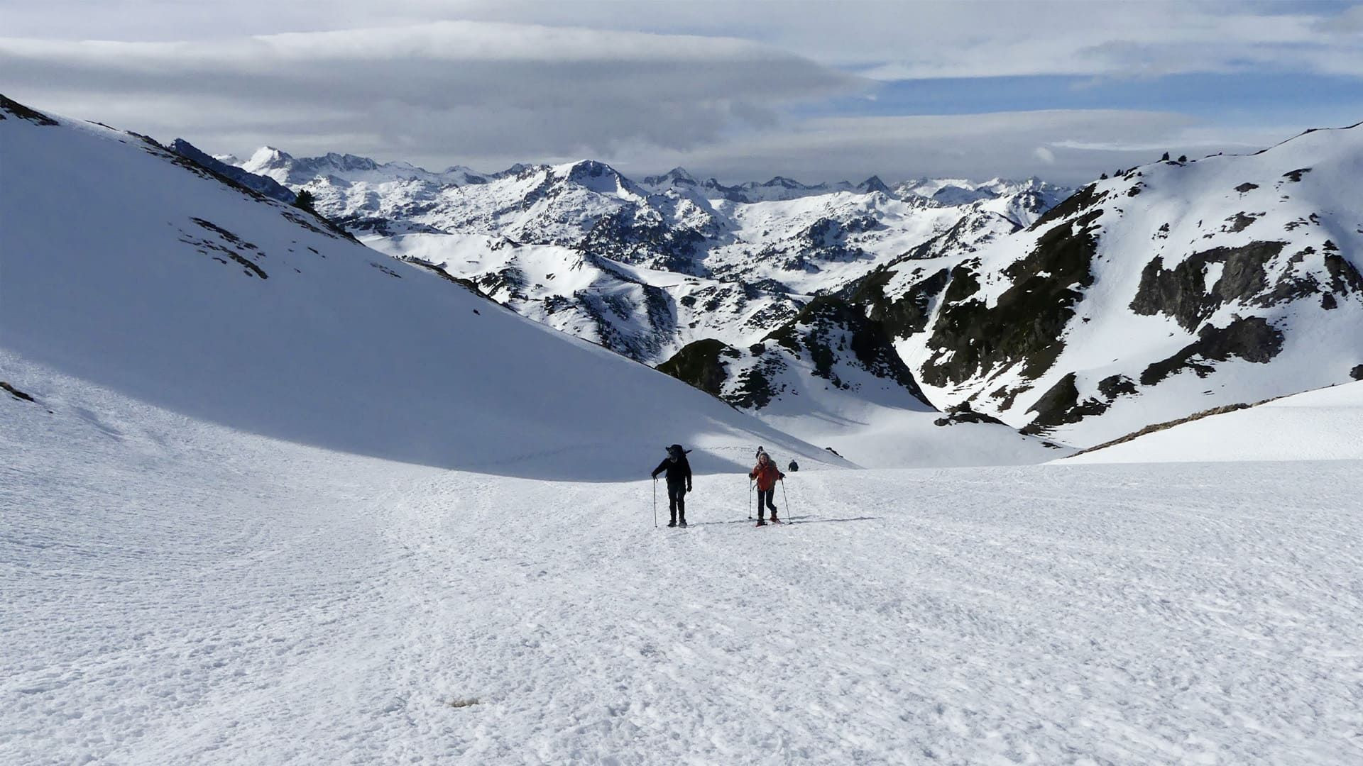 © Michel Madré Randonneurs à raquettes face aux sommets - Encantats - Pyrénées