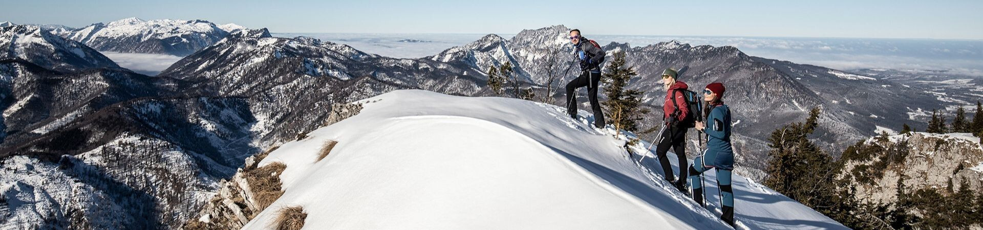 Groupe de randonneurs en raquettes sur une crête enneigée - Alpes