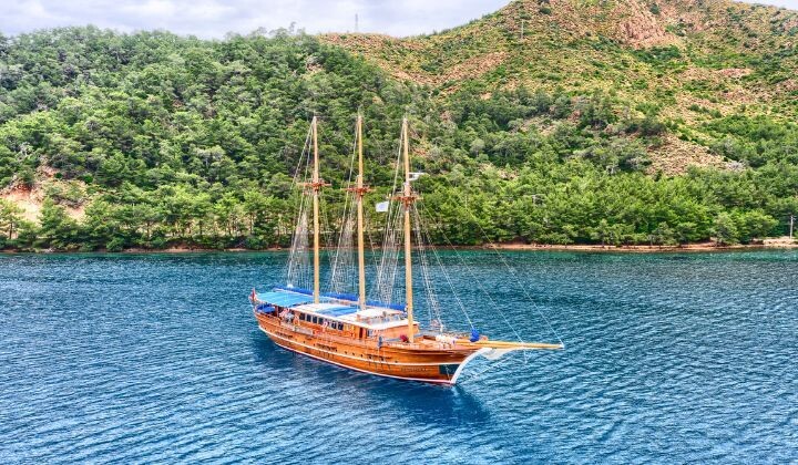 Goélette en bois traditionnelle dans une baie bordée de pins - Côte turque - Turquie