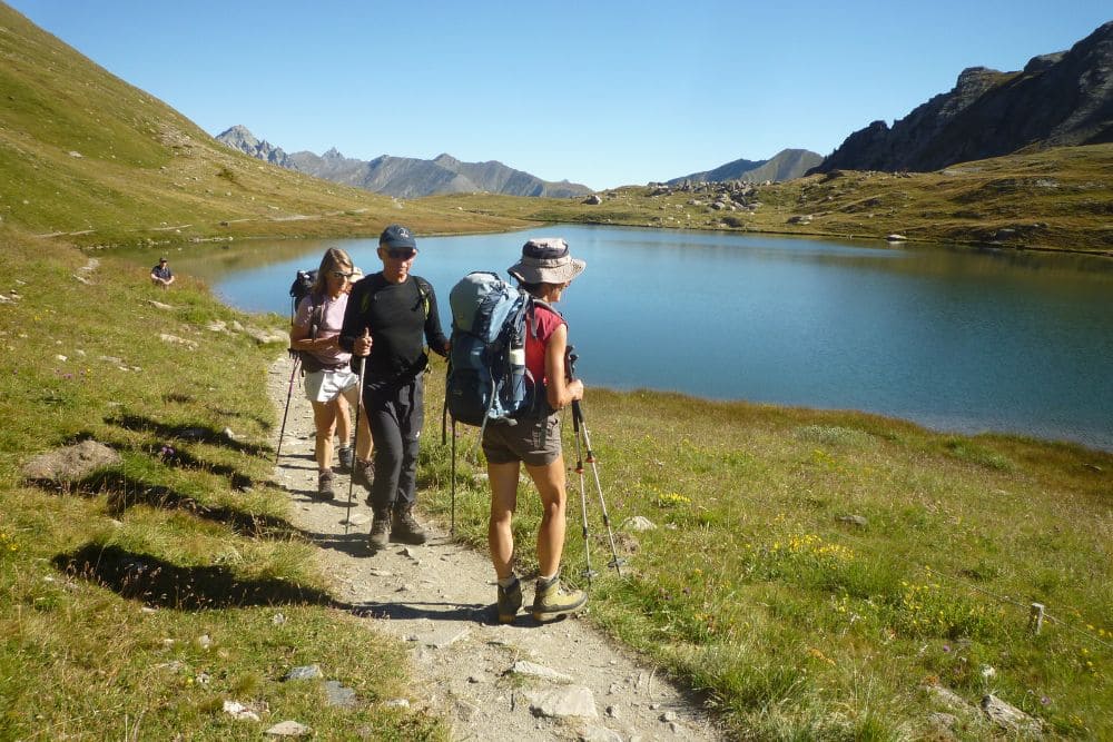 Randonneurs au bord d'un lac sur la Grande Traversée des Alpes © Raymond Chabanier