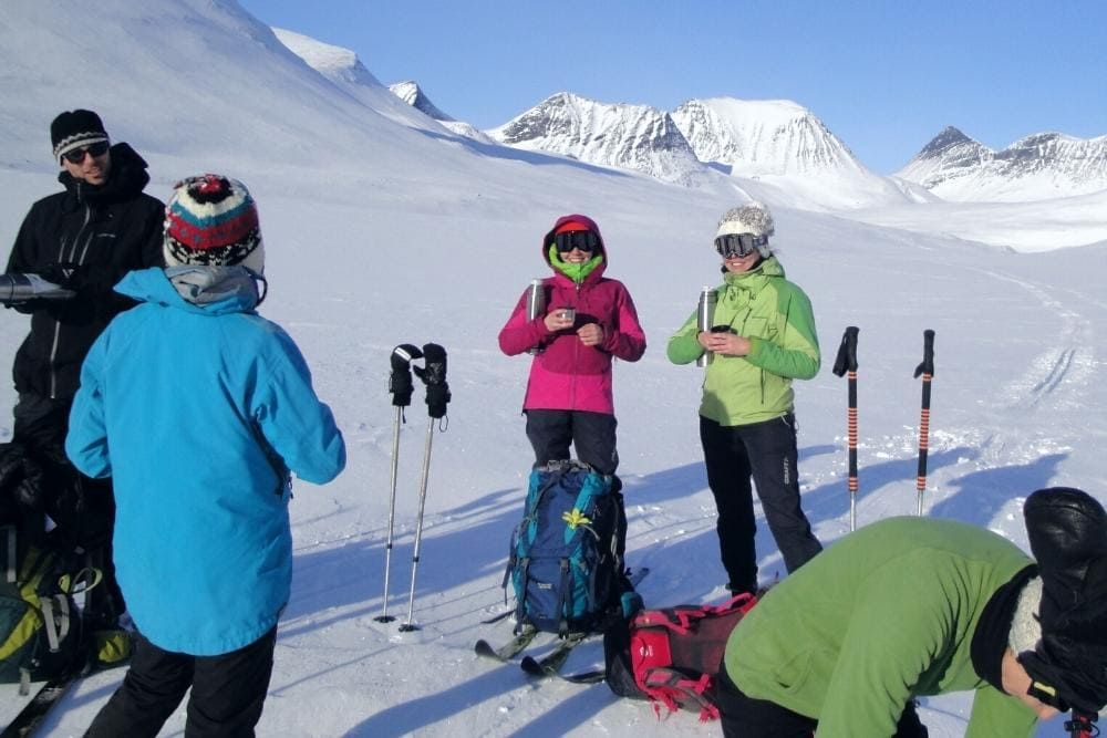 Groupe de skieurs sans pulka buvant une boisson chaude sur la Kungsleden © Doriane Argaud