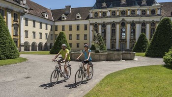 Cyclotouristes passant près d'un chateau en Autriche