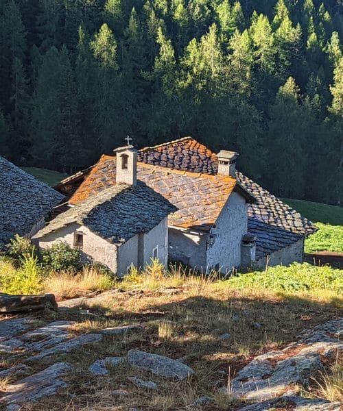 Hameau avec maison en toit de lauzes sur le chemin 