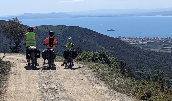 Cyclistes VTT dans la descente vers Cadaques et vue sur Roses