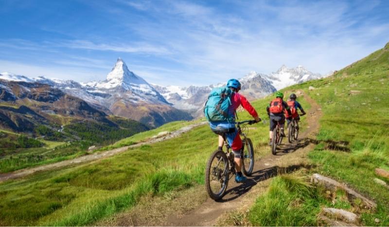 Groupe de cyclistes en vélo tout terrain (VTT) près du Mont Cervin dans les Alpes Suisses © AdobeStock